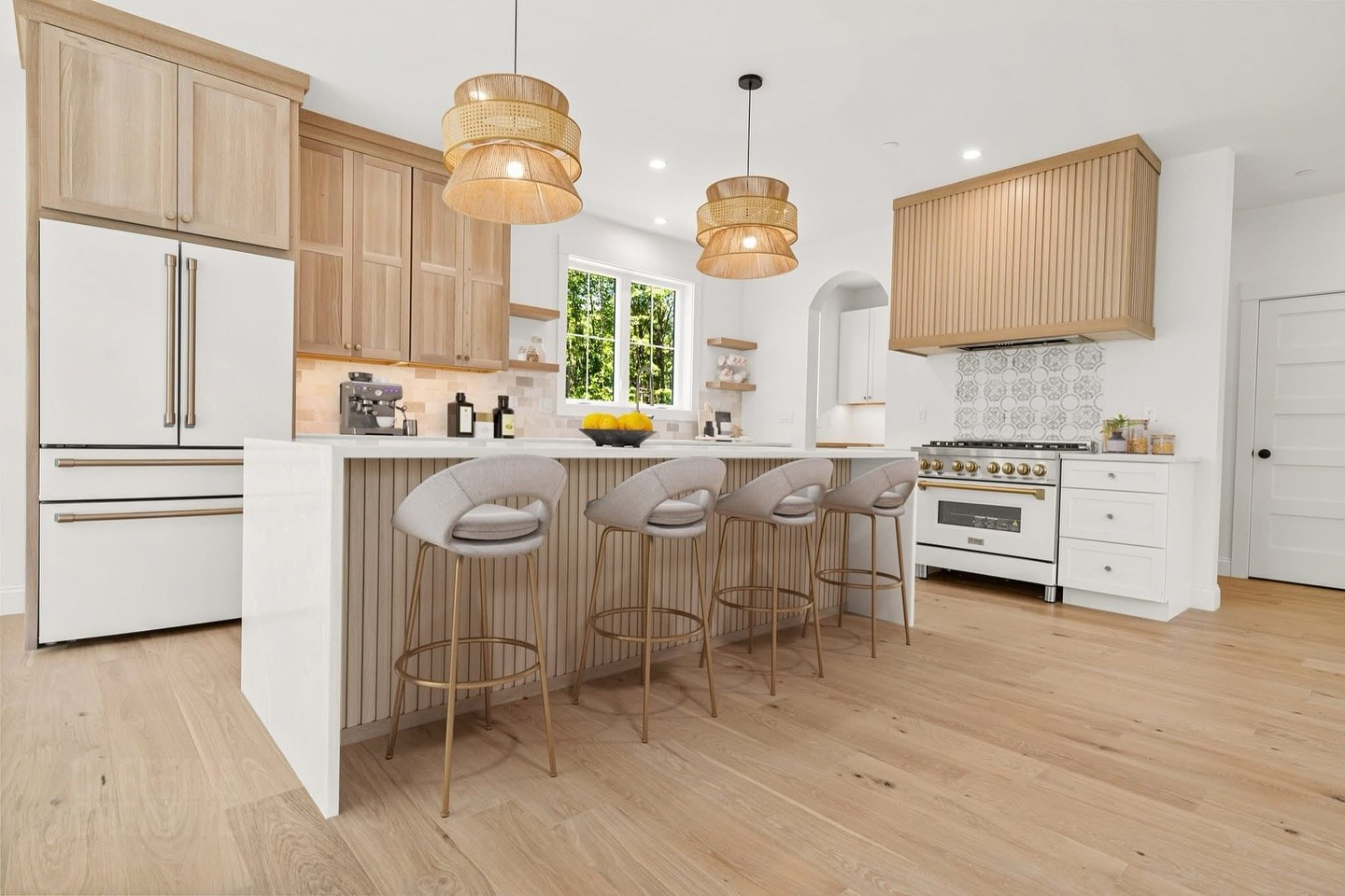 Custom kitchen with white oak cabinetry and rattan pendant lighting